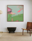green and blue abstract art print on white wall. framed in oak