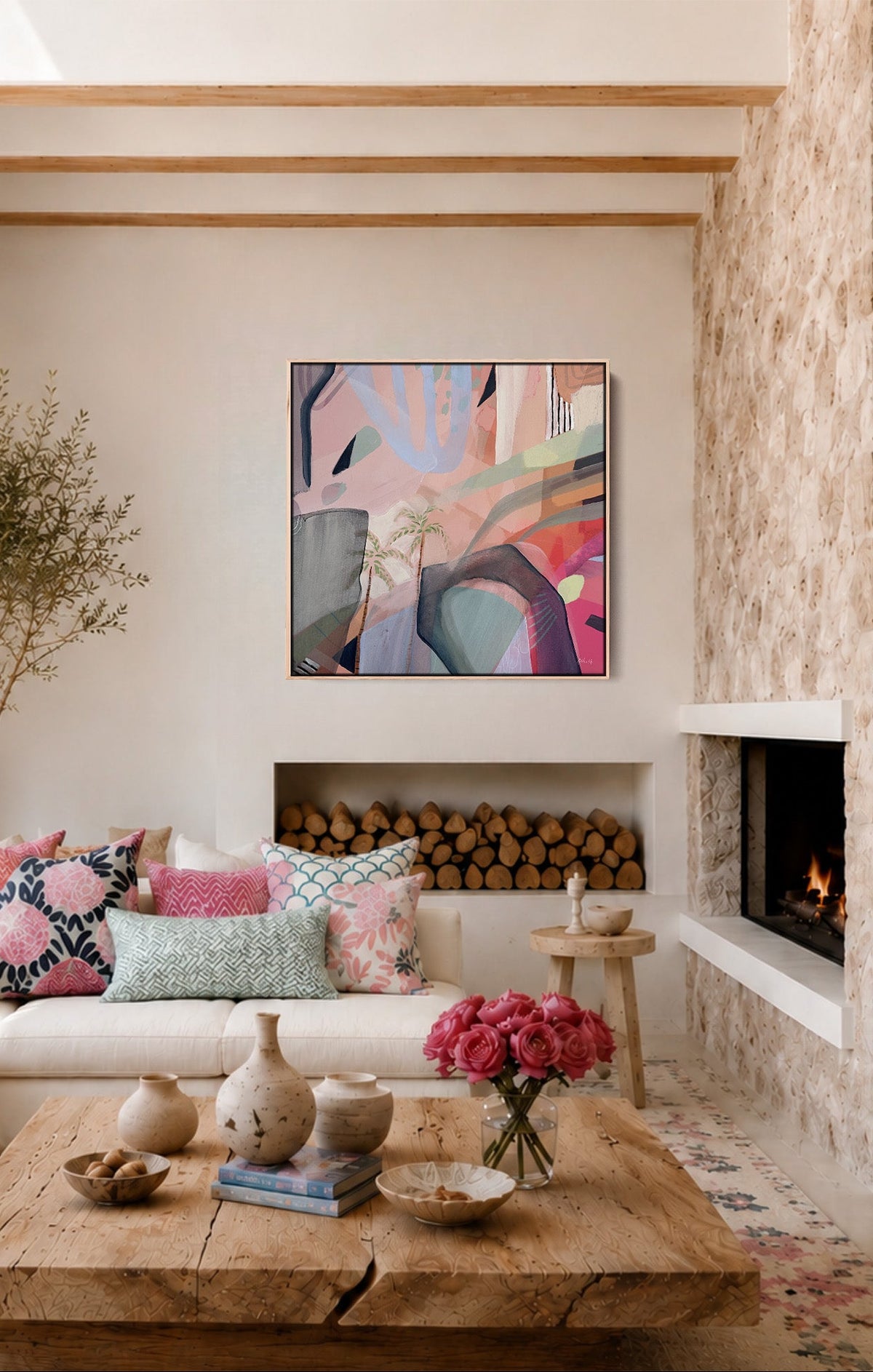 A modern living room with a white sectional sofa, colorful throw pillows, a rustic wooden coffee table, a stone fireplace, and a vibrant abstract painting hanging on the wall.