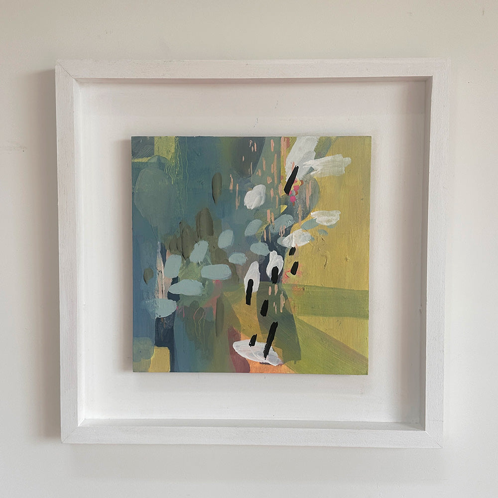 Framed abstract painting with a white border on a light gray wall
