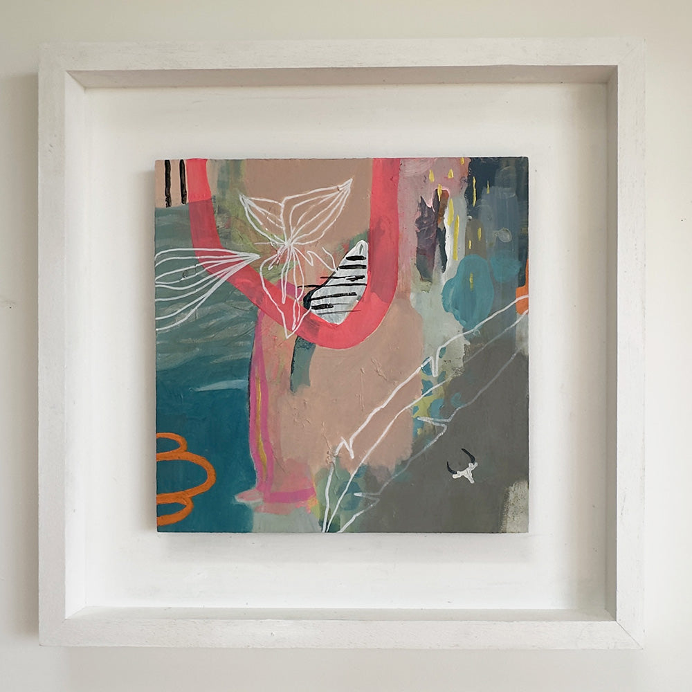 Framed abstract artwork with colorful elements on a light background