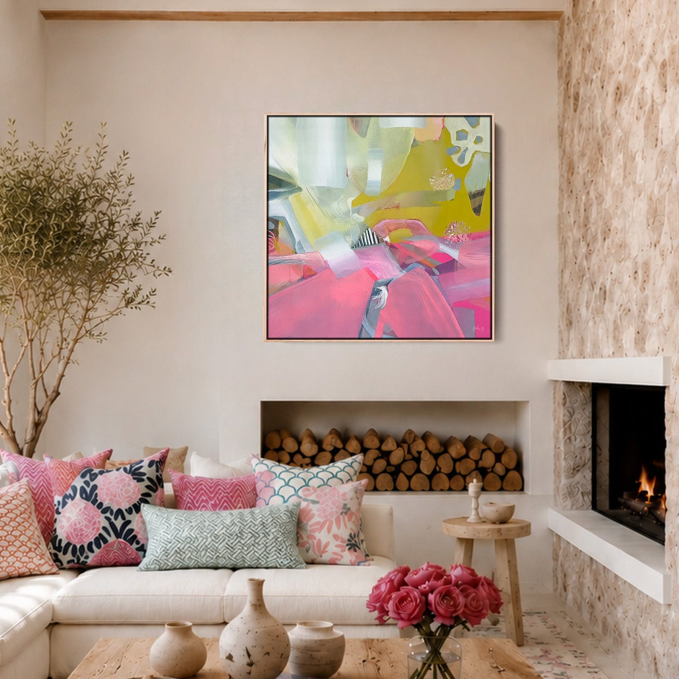 A bright, modern living room with a white sectional sofa, colorful patterned pillows, a rustic wooden coffee table, a stone fireplace, and a vibrant abstract painting hanging on the wall.